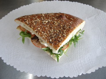 Pide-Brot gefüllt mit: Mozzarella-di-Bufala, Rucola und Tomaten an Oliven Paste. Kantenlänge ca. 15 cm.