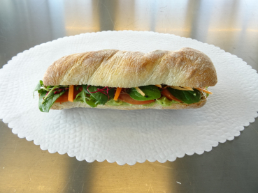 Panini (Vegan) gefüllt mit: Blattspinat, Rucola, Rüeblistreifen, Sprossen, Tomaten an Guacamole/Avocado-Sauce. - ca. 20cm.