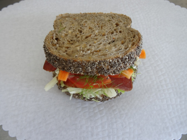 Chia-Maya-Brot gefüllt mit: Bündnerfleisch, Rüebli-, Fenchelstreifen, Eisbergsalat, Tomaten an einer Kräuter-Meerrettichsauce. ca. 10 cm.